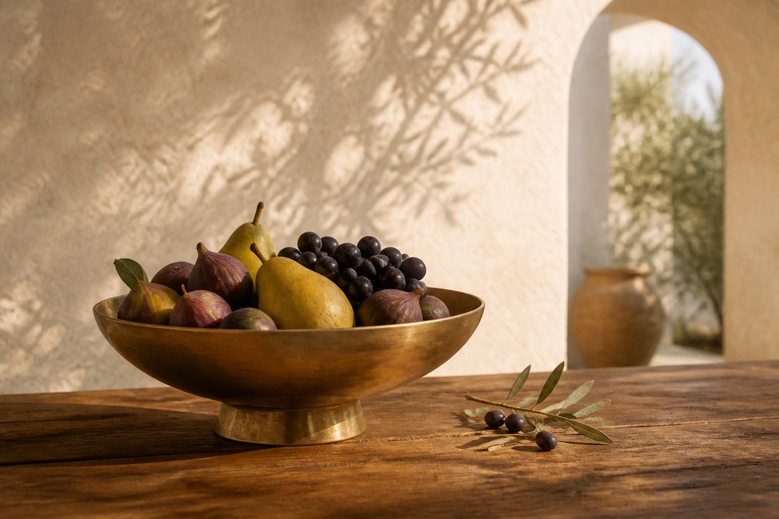 Seasonal fruit in an antique-gold bowl on a warm wooden table