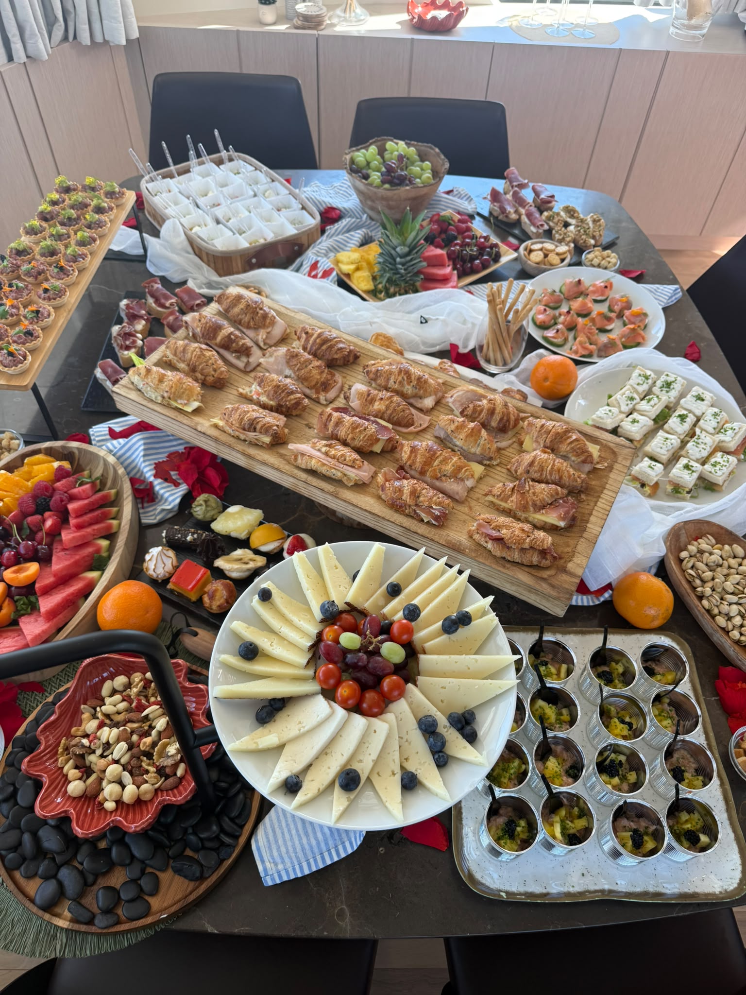 A generous celebration table with pastries, fruit and small plates
